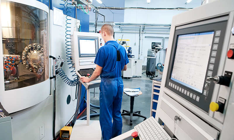 worker operating CNC machine center