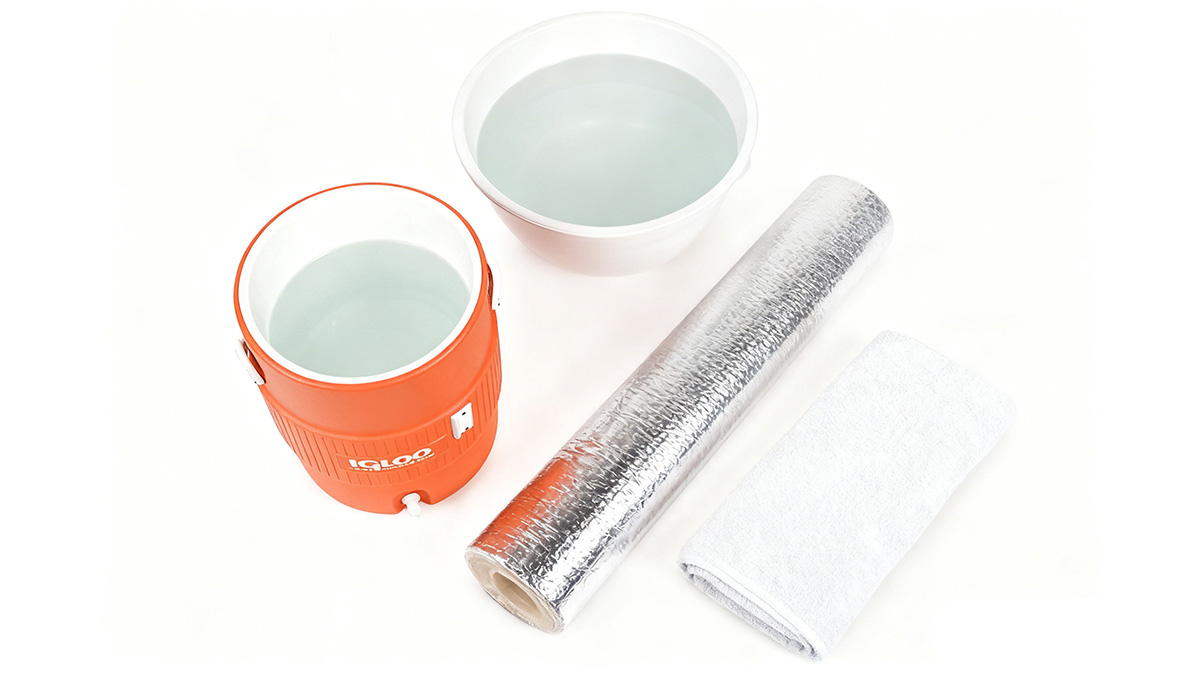 an igloo water cooler, tin foil paper, towel and warm water an igloo water cooler, tin foil paper, towel and warm water